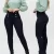 Pantalon noir taille haute pour femme avec boutons dorés style officier, porté par un mannequin.